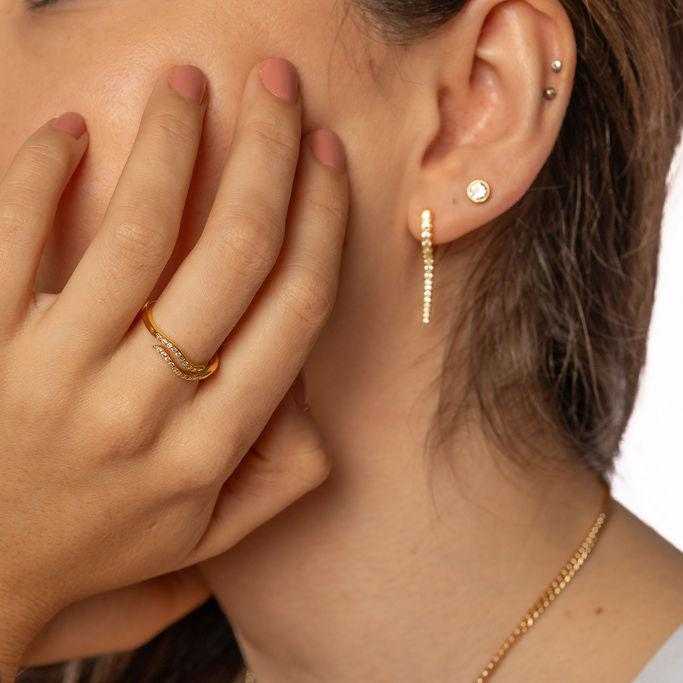 Delicate Infinity Embrace Ring with double-band cubic zirconia design in 18k gold-plated sterling silver on hand.