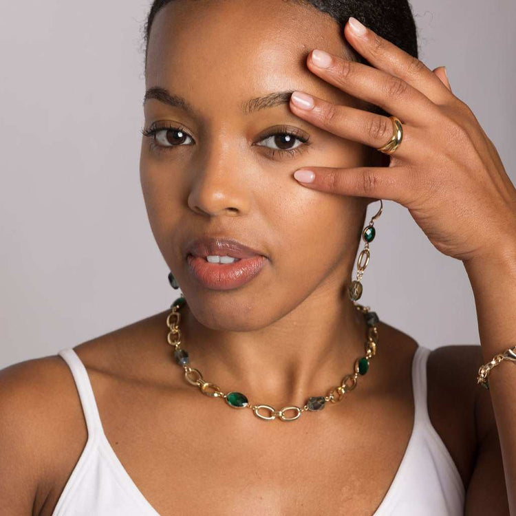 Gold-toned double band minimalist ring with sleek, modern design on a woman's hand.